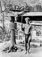 view M0005678: Ifugaos warrior standing in front of a structure, Philippines