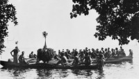 view M0005342: Canoes surrounding a dancing figure from the Duk-Duk secret society, Papua New Guinea.