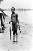 view M0012546: Young girl wearing brass spiral anklets and holding an umbrella. Ibo, Nigeria / M0012547: Man wearing a chain mail head-dress, Ghana