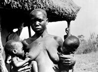 view M0013583: A Lango woman breastfeeding twins / M0013584: A woman carrying a baby