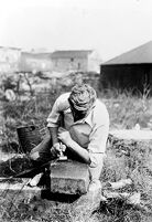 view M0015964: Leon Coutier making flint arrowhead using technique of pressure-trimming from the shoulder