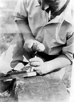 view M0015967: Leon Coutier demonstrating the production of blades by the use of the hammer and punch method