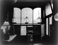 view M0019044: Interior of N. F. Tyler Dispensing Chemist at 87 Abingdon Road, London showing the front window and carboys in position